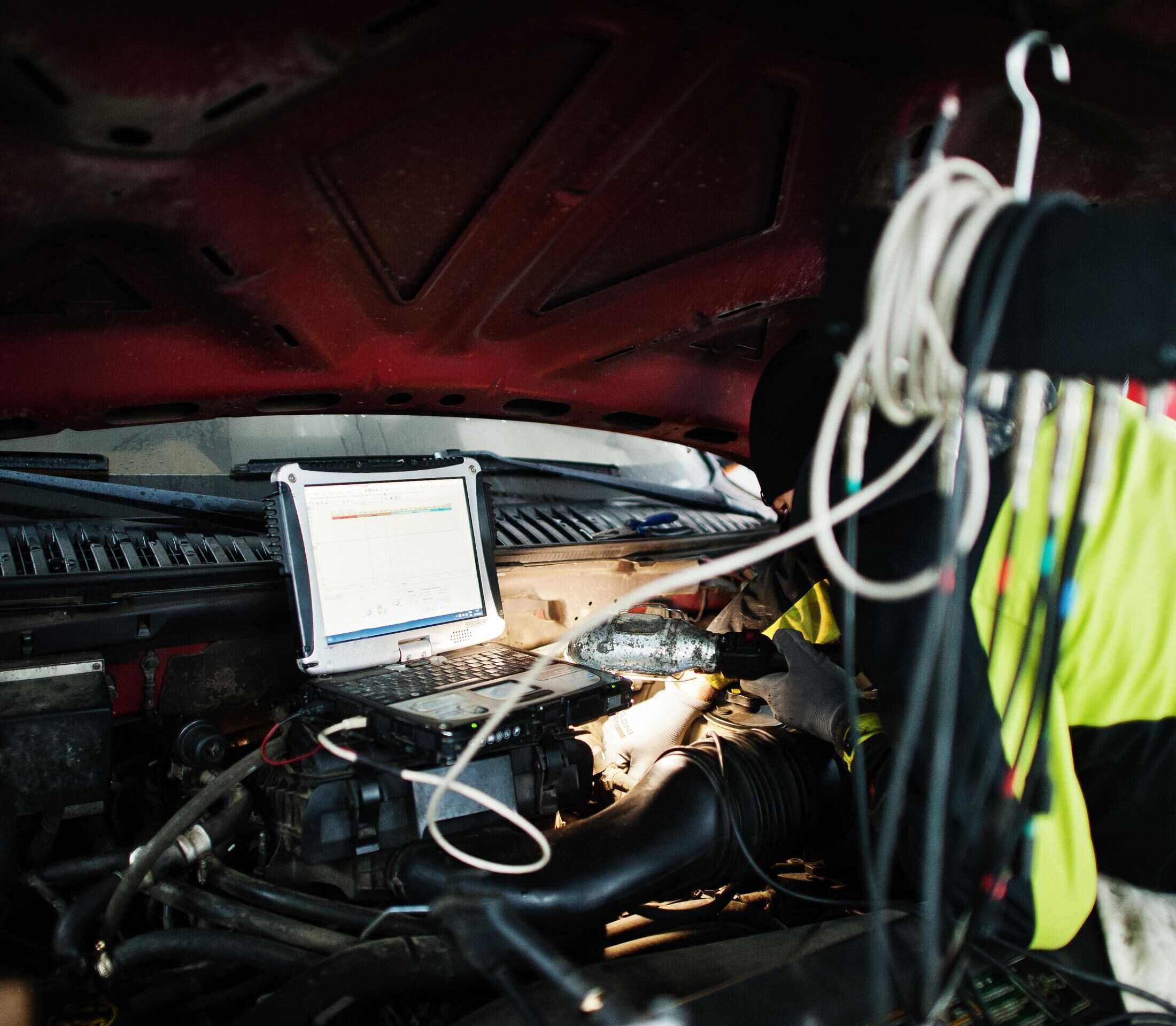 Engine diagnostics being performed by a technician using a laptop inside a vehicle at Greens Garage Suffolk.